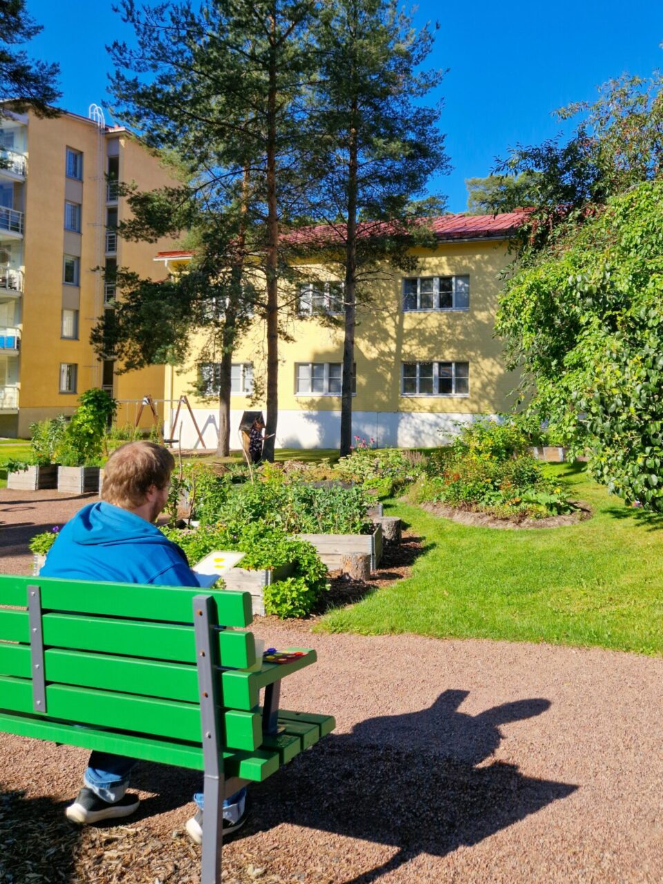 Penkillä istuva ihminen katsoo DiakonKylän puutarhaa